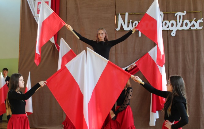 Zdjęcie przedstawiające piramidę z dziewcząt tańczących z flagami biało-czerwonymi